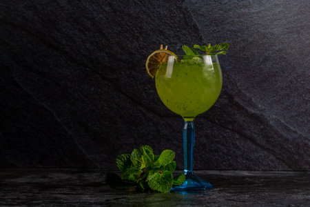 Refreshing alcoholic drink with lemon and mint in an ice glassの写真素材