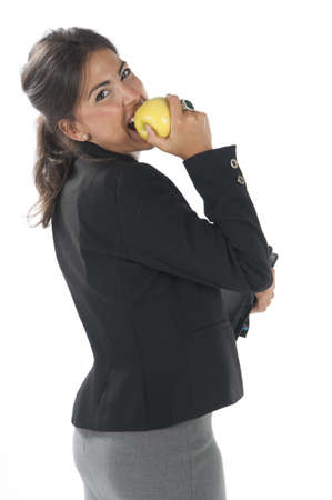 Waist up, healthy young business executive woman, on white, eating an apple.の写真素材