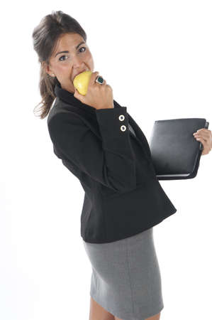 Waist up, healthy young business executive woman, on white, eating an apple.の写真素材