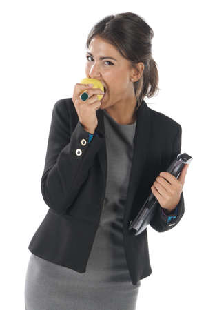Waist up, healthy young business executive woman, on white, eating an apple.の写真素材
