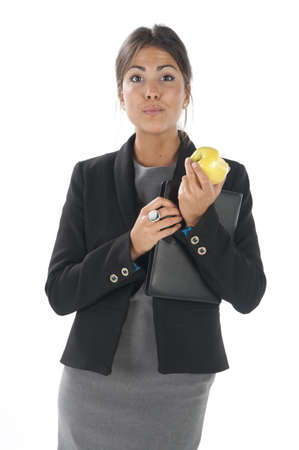 Waist up, healthy young business executive woman, on white, eating an apple.の写真素材