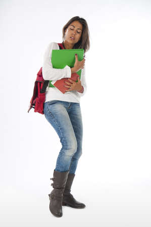 Young bussy girl student, on white, wearing jeans and t-shirt, holding notebooks.の写真素材
