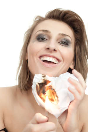 portrait of young beautiful happy smiling woman with burning paper heart and leaking makeup on...