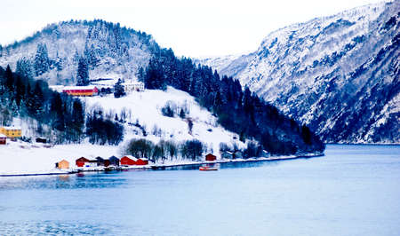 Houses by a lake in a norwegian mountain area in winterの写真素材