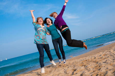 Three girls jump at the beach