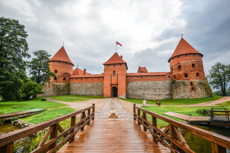 Trakai, Lithuania - August 15, 2017: Landscape of Trakai Island Castle, lake and wooden bridge, Lithuania. Trakai Island Castle and bright blue dramatic sky with clouds.のeditorial素材