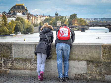 Prague, Czech Republic - October 10, 2017: Couple looks at Vltava river and bridges near Prague city center, Prague Czech Republic. Romance in Pragueのeditorial素材