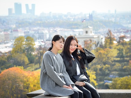 Prague, Czech Republic - October 10, 2017: Two pretty Asian girls taking selfie and looks at the old city of Prague from observation decks near Prague Castle, Prague Czech Republicのeditorial素材