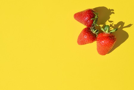 Fresh Strawberries close up. Strawberry isolated on bright yellow backgroundの写真素材