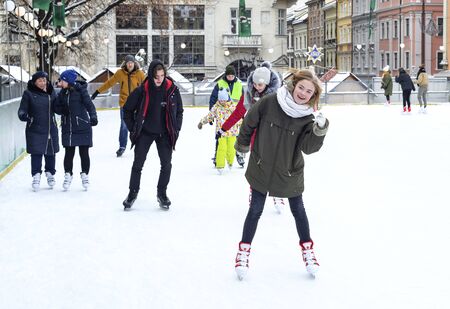Lviv, Ukraine - December 24, 2019: People of all ages ice skating on an ice rink. Youth have fun and skatesのeditorial素材