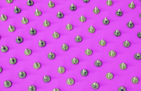Screws. Screws background. Top view, flat lay. Screws isolated on pink background