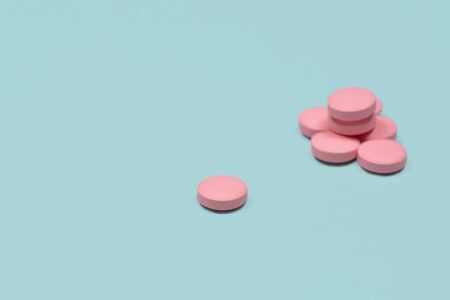 Medical background with pills. Pink Pills on blue or mint background. Macro photo. Copy space