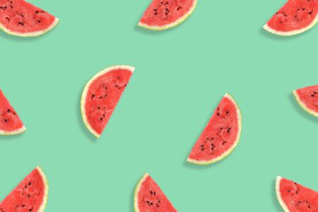 Flat lay of watermelon half slices on mint background. Watermelon pattern. Summer fruit. Creative Minimal summer pop art concept.の写真素材