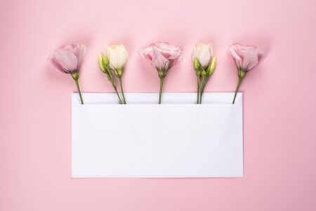 Trendy banner for Valentines Day, International Womens Day or mothers day. Party or wedding invitation. Five Eustoma flower arrangement with flowers and blank card, on pink backgroundの写真素材
