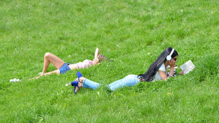 Krakow, Poland - May 20, 2019: Two young women lie in the grass Wawel Castle near Vistula River in Krakow, Poland.のeditorial素材