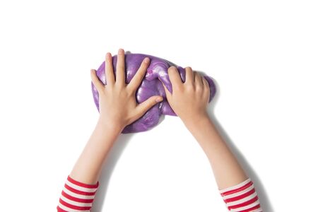 Teenager hands and purple shiny slime. Child girl plays with slime isolated on white. Home educational games concept. Top view, flat lay banner.の写真素材