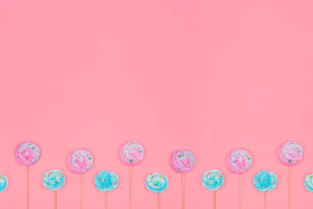 Colorful Marshmallow or meringue cake toppers on pastel pink background. Trendy banner with Marshmallow on stick and copy spaceの写真素材