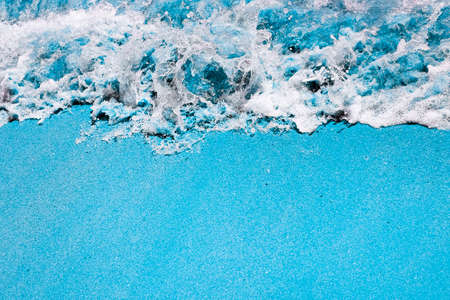 Deep water, stormy waves and sandy beach toned in blue. Beautiful coastline with copy space. Top view. Pop art concept. Summer Banner with copy space.の写真素材