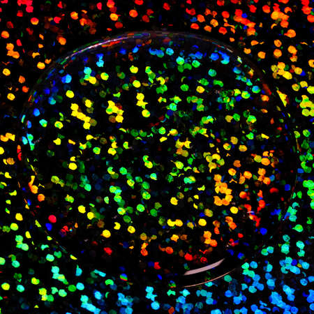 Transparent gel drop on neon rainbow background. Top view. Virus protection or cosmetics concept....