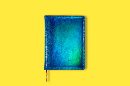 Neon Green and blue closed notebook mockup isolated on yellow background. Top view on mock up of...