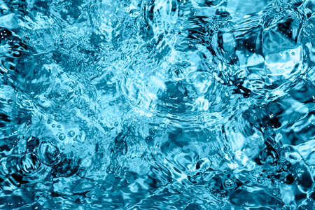 Blue Pool or hot tub water background. Ripples on blue transparent water in swimming pool with light...