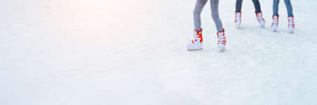 Legs skating on ice. Long banner with copy space. People go ice skating in rented skates. Winter...