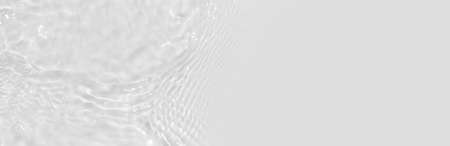 Water texture with circles on the water overlay effect for photo or mockup. Organic light gray drop shadow caustic effect with wave refraction of light. Long banner with copy space.の写真素材