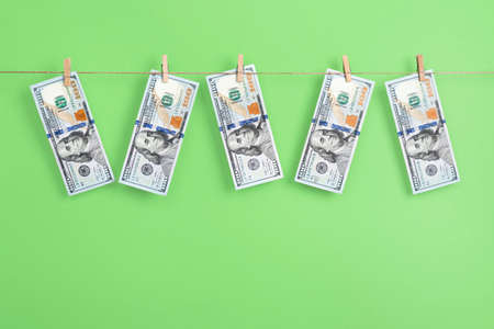 Dollars money are hanging by a thread on a clothespin. Money Laundering concept.の写真素材