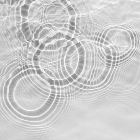 Water texture with circles on the water overlay effect for photo or mockup. Organic drop shadow caustic effect with wave refraction of light on a white or gray wall background.の写真素材