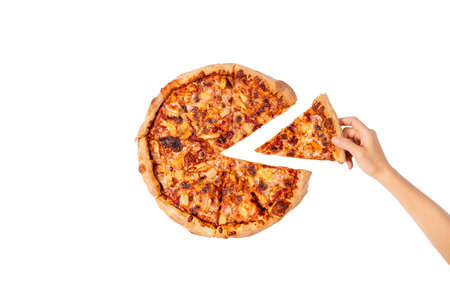 Hand taking a slice of pizza. Big Hawaii pizza without one piece. Top view on Hawaii pizza. Concept...