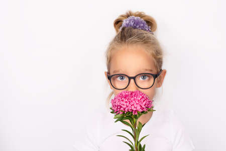 Child girl holding one pink aster flower isolated on white background. International mothers day concept.の写真素材