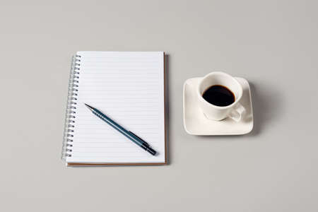 Notepad, pen and a cup of coffee isolated on light gray background. Notepad with copy space. Office,...
