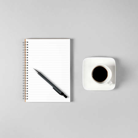 Notepad, pen and a cup of coffee isolated on light gray background. Notepad with copy space. Office, business, discreet style.の写真素材