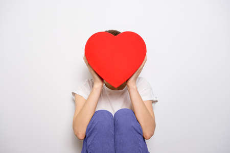 Woman holding a big red box in shape of a heart. Trendy video banner for Valentines Day, International Womens Day or mothers day.の写真素材