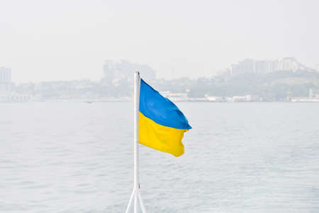 Flag of Ukraine or Ukrainian flag on the background of Dnieper river and Kyiv city, capital of Ukraine.の写真素材
