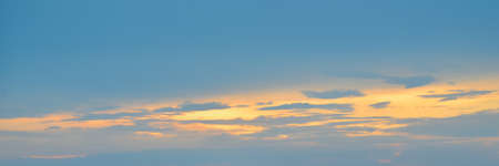 Beautiful evening sky in blue, yellow and orange colors. Sunset sky. Long banner