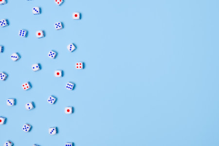 Small dice isolated on a blue background. Gambling devices. Copy space for text. Game of chance conceptの写真素材