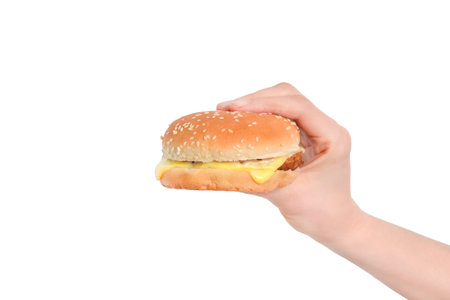 Hand holds big cheeseburger isolated on white background close-up. Concept of fast food or junk food.の写真素材