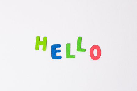 The word hello made of colored wooden letters on a light gray background. Blue and red letters form the greeting word hello.の写真素材