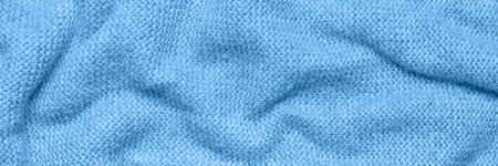 Close up texture of blue crumpled woven fabric with a subtle pattern of evenly spaced tiny dots, providing a soft, neutral background ideal for design and creative projects. Long horizontal bannerの写真素材