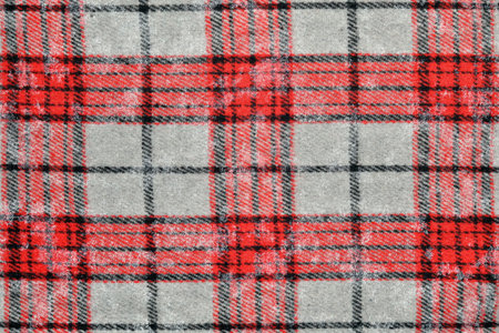 Close up of red and black crumpled tartan plaid fabric with gray background. Perfect for fashion, textile, or pattern design projects.の写真素材