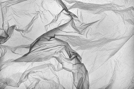 A textured light gray crumpled paper background with natural creases and folds.の写真素材