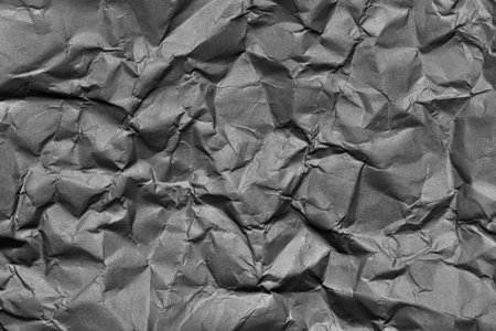 A textured gray crumpled paper background with natural creases and folds. Ideal for design projects, digital graphics, or creative presentations requiring a vibrant.の写真素材