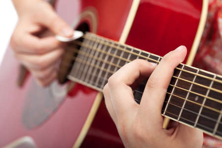 Musician playing on acoustic guitar - closeup on hands
