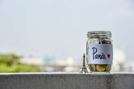 Saving planing for travel to France budget of holiday concept, stack of coins money in the glass bottle with Eiffel Tower model. Financial concept.の写真素材