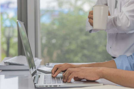 Close up hands of business man working with laptop on desk, boss or manager complaining standing behind for statement. Business working teamwork and leadership concept.の写真素材