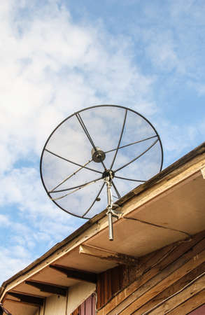 Satellite dish antenna for television on house roof with blue sky backgraund, in countryside, Thailand.の写真素材