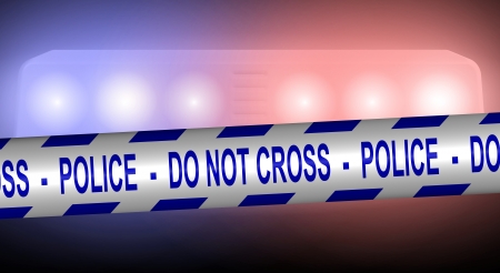 Blue and white police tape spread in front of police car lightsの写真素材