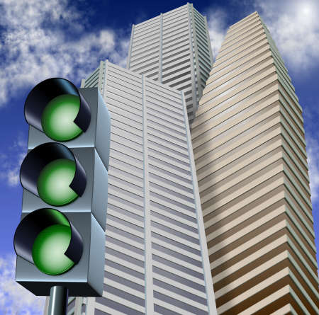 Traffic light with three green lights and city business buildings in the backgroundの写真素材