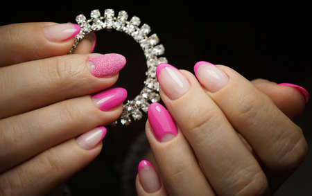 Beautiful bright natural nails with perfect clean manicure. Nail drill machine and cuticle nipper are used simultaneously to make such a clean manicure.の写真素材